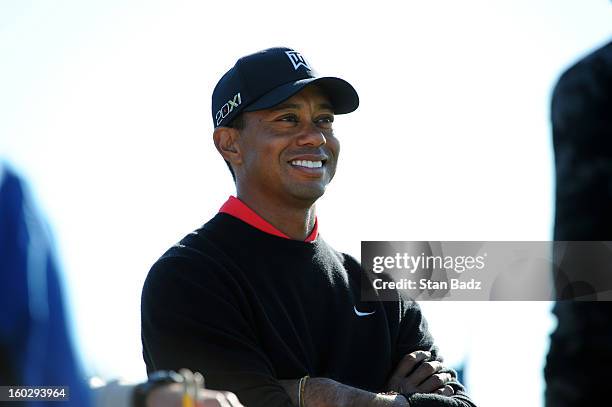 Tiger Woods smilies as he waits to play the 18th hole during the final round of the Farmers Insurance Open at Torrey Pines Golf Course on January 28,...