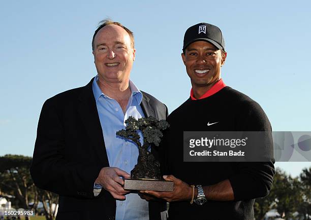 Farmers Insurance CEO Jeff Dailey and Tiger Woods pose with the winner's trophy on the 18th green during the final round of the Farmers Insurance...