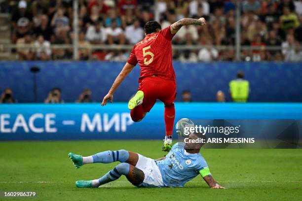 Manchester City's English defender Kyle Walker attempts to tackle Sevilla's Argentinian forward Lucas Ocampos during the 2023 UEFA Super Cup football...