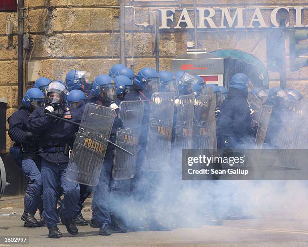 Police advance through tear gas on anti-G8 protesters July 20, 2001 in central Genoa. Approximately 600 violent protesters fought with police,...