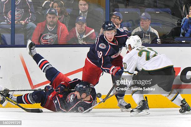 Ryan Johansen of the Columbus Blue Jackets and Cody Eakin of the Dallas Stars battle for a loose puck over a fallen R.J. Umberger of the Columbus...