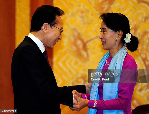 Pro-democracy leader Aung San Suu Kyi shakes hands with South Korean President Lee Myung-Bak during their meeting at the presidential house on...