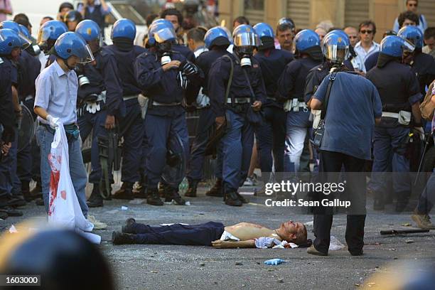 Police surround the body of Carlo Giuliani, a demonstrator they shot to death during protests in central Genoa, July 20, 2001. Approximately 600...