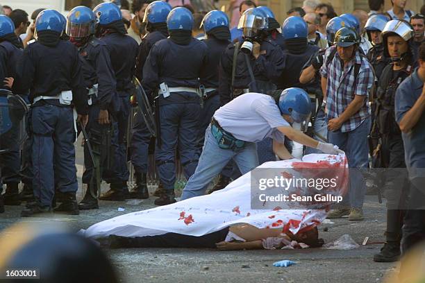Police cover the body of Carlo Giuliani , a demonstrator they shot to death during protests in central Genoa, July 20, 2001. Approximately 600...