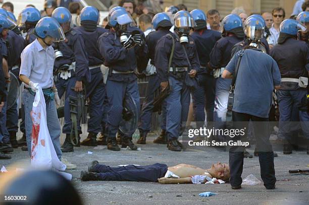 Police surround the body of Carlo Giuliani, a demonstrator they shot to death July 20, 2001 during protests in central Genoa. Approximately 600...