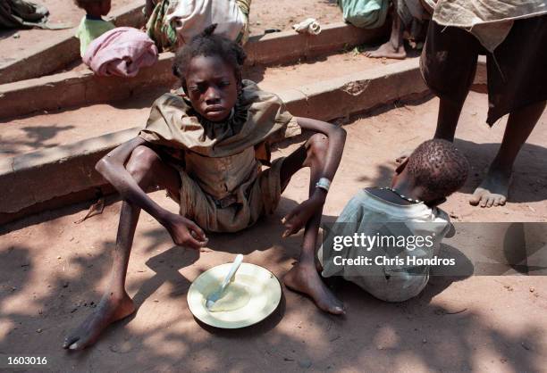 Starving and sick girl eats in September of 1999 at a feeding center in Malange, Angola. Malange, a rural town surrounded by UNITA rebels, serves as...