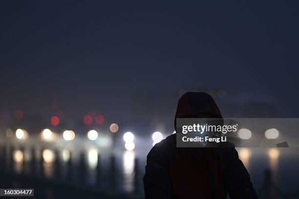 Men wearing the mask rides a bicycle on the street during severe pollution on January 29, 2013 in Beijing, China. The 4th dense fog envelops Beijing...