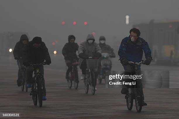 Beijing residents wearing the mask ride amid fog during severe pollution on January 29, 2013 in Beijing, China. The 4th dense fog envelops Beijing...