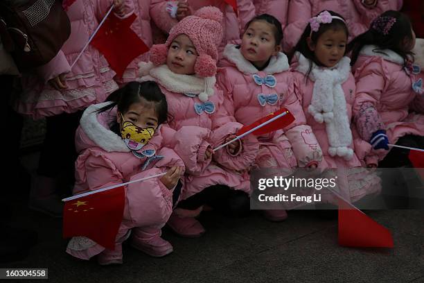 Little girl wears the cartoon mask at the Tiananmen Square during severe pollution on January 29, 2013 in Beijing, China. The 4th dense fog envelops...