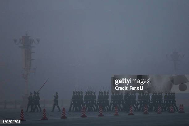 Chinese paramilitary police officers march during the flag-raising ceremony with severe pollution at Tiananmen Square on January 29, 2013 in Beijing,...
