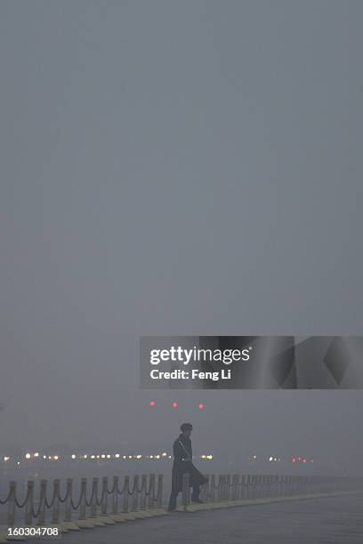 Chinese paramilitary police officer passes through Changan Avenue during the flag-raising ceremony with severe pollution at Tiananmen Square on...