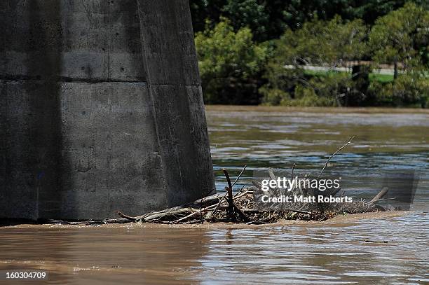 Debris is seen caught on a bridge in the Brisbane river as parts of southern Queensland experiences record flooding in the wake of Tropical Cyclone...