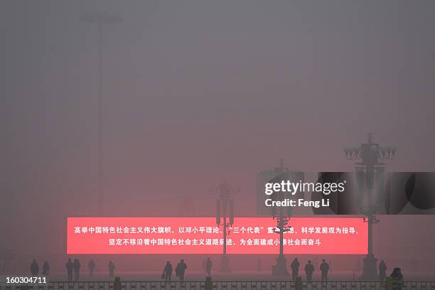 Tourist walk on the Tiananmen Square during severe pollution on January 29, 2013 in Beijing, China. The 4th dense fog envelops Beijing with pollution...