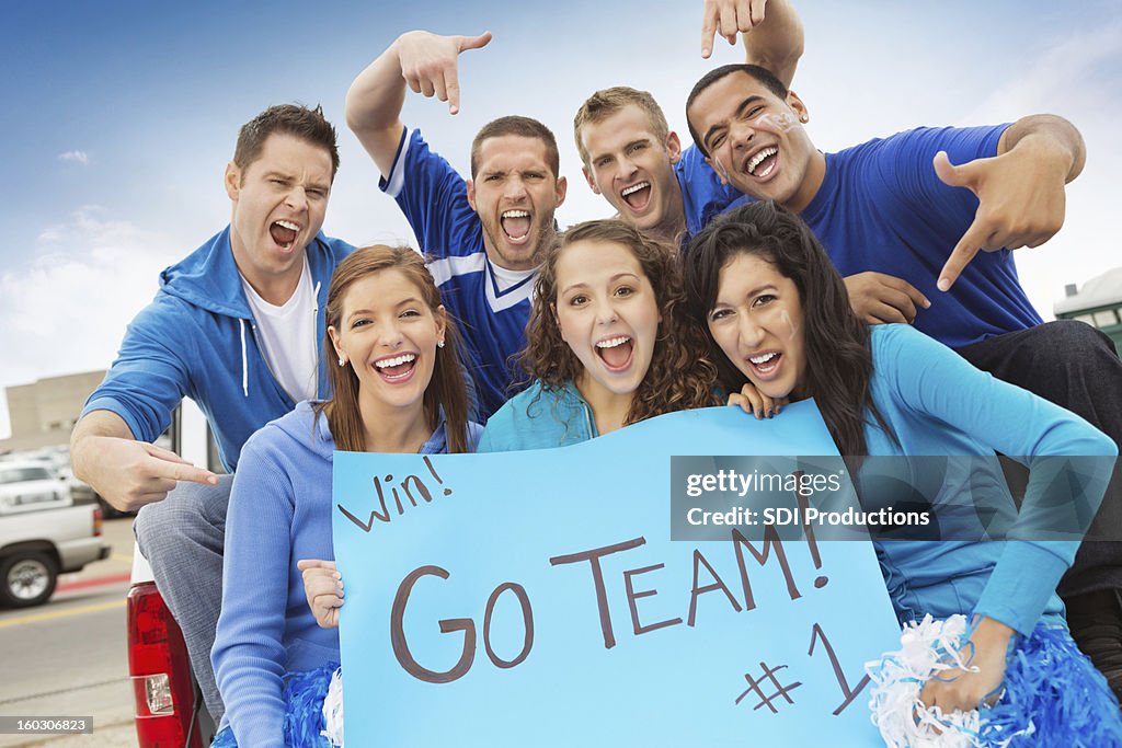 Group of sports fans cheering on team while tailgating