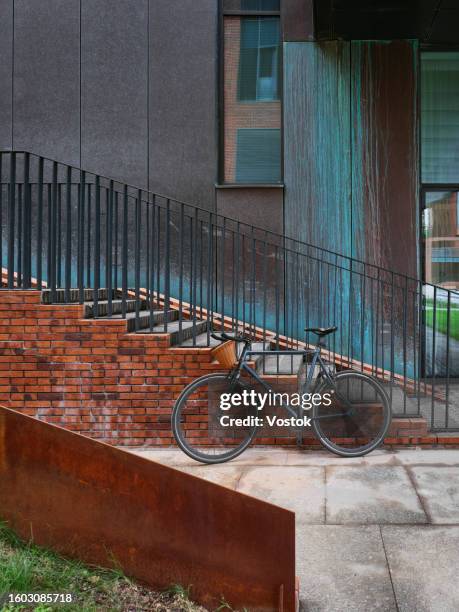 bike parked outside a new apartment building - hc stock pictures, royalty-free photos & images
