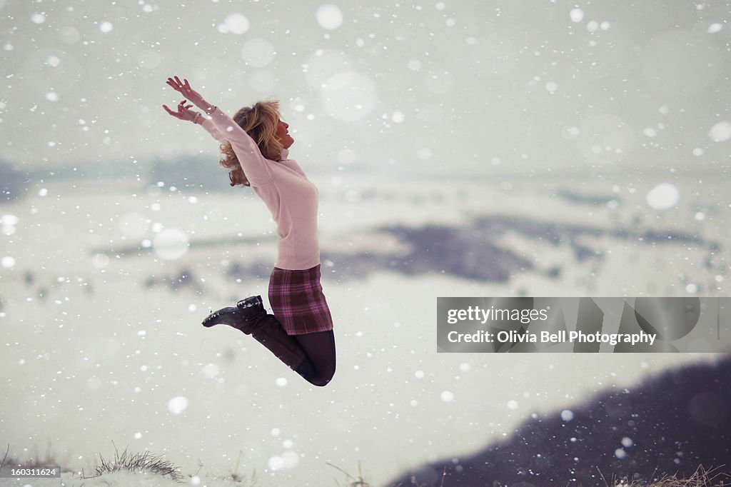 Women Jumping on top of Valley in Snow Storm