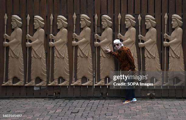 Parsi man poses for a photo near the carvings of guardians of faith on the occasion of Parsi new year. The word 'Nav' means new and 'Roz' means day....