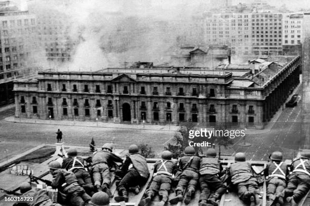 Chilean Army troops positioned on a rooftop fire on the La Moneda Palace 11 September 1973 in Santiago, during the military coup led by General...