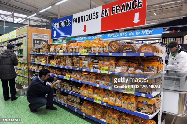 An employee organizes goods on shelves with "Made in France" producst on January 29, 2013 in a Leclerc hypermarket in Lanester, western of France....