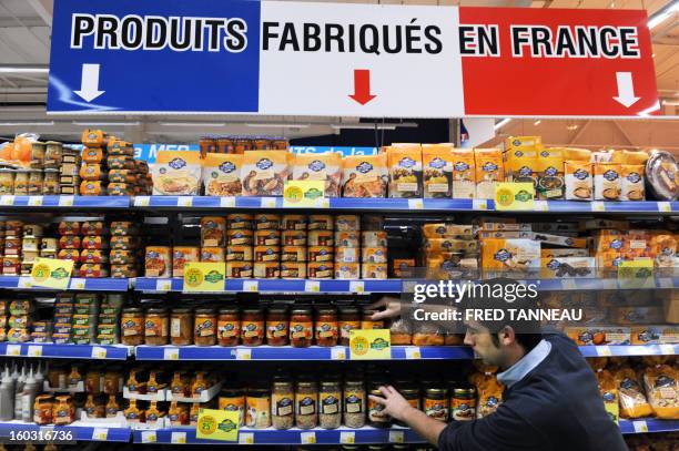 An employee organizes goods on shelves with "Made in France" producst on January 29, 2013 in a Leclerc hypermarket in Lanester, western of France....