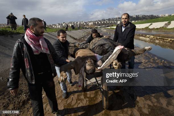 Syrians recover the bodies of executed men along a canal in the northern city of Aleppo before transferring the corpses to a hospital where relatives...