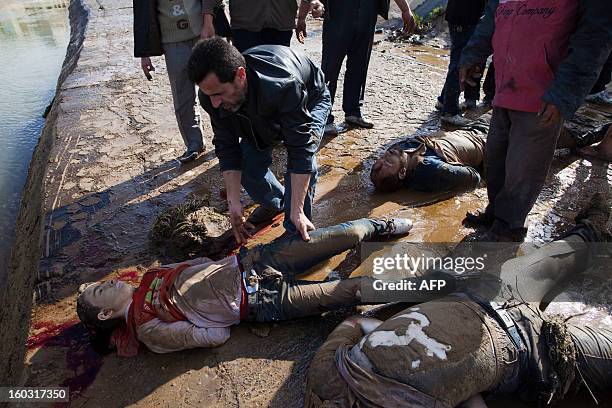 Syrians recover the bodies of executed men along a canal in the northern city of Aleppo before transferring the corpses to a hospital where relatives...