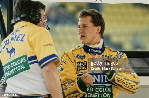 British motorsport engineer Ross Brawn in conversation with German racing driver Michael Schumacher, in his yellow coveralls, ahead of the 1993 San...