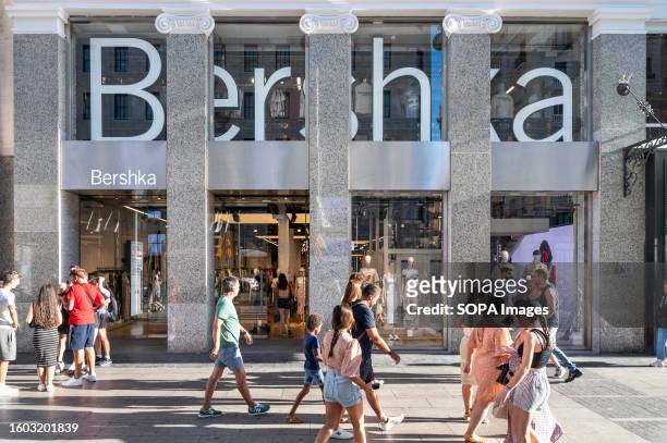 Shoppers and pedestrians walk past the Spanish fashion brand owned by Inditex, Bershka, store in Spain.