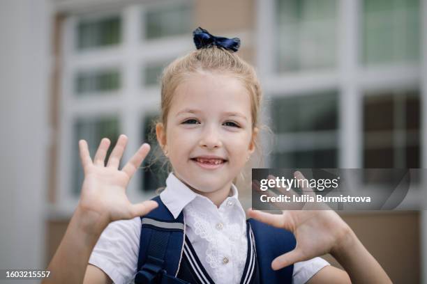 portrait of pretty preadolescent schoolgirl in school uniform looking at camera - portrait of a young girl with gappy teeth and blond hair stock pictures, royalty-free photos & images