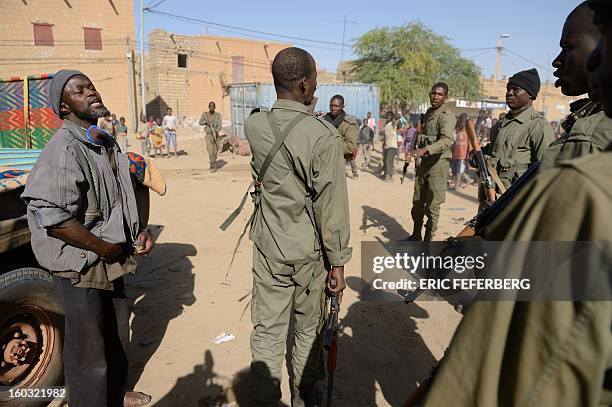 Malian soldiers talk on January 29, 2013 after checking a man suspected of being an Islamist in Timbuktu after a French-led troops freed the northern...