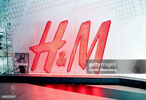 Logo stands illuminated in the window of a Hennes & Mauritz AB store in Stockholm, Sweden, on Tuesday, Jan. 29, 2013. Hennes & Mauritz AB, Europe's...