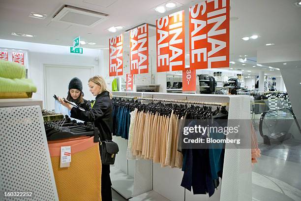 Customers browse discounted garments displayed for sale inside a Hennes & Mauritz AB store in Stockholm, Sweden, on Tuesday, Jan. 29, 2013. Hennes &...