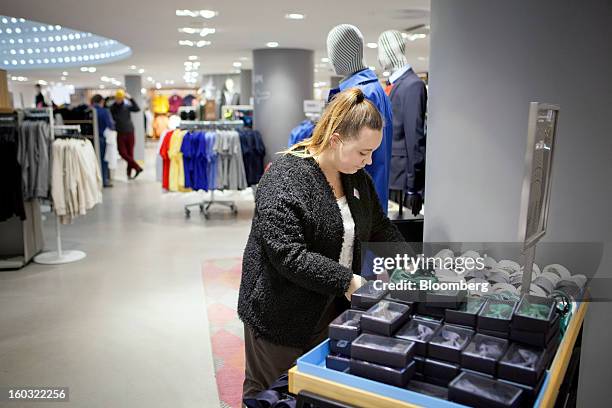 An employee arranges a display of men's accessories inside a Hennes & Mauritz AB store in Stockholm, Sweden, on Tuesday, Jan. 29, 2013. Hennes &...