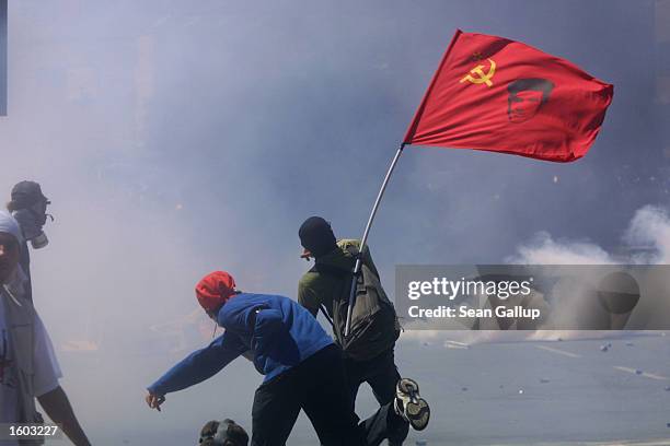 Anti-G8 protesters throw stones at police through a fog of tear gas July 21, 2001 in Genoa, Italy. Several thousand violent protesters battled with...