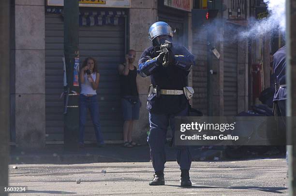 Riot policeman fires tear gas at anti-G8 protesters July 21, 2001 in Genoa, Italy. Several thousand violent protesters battled with police and...