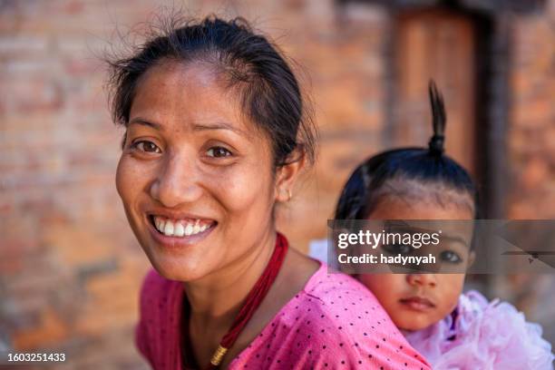 nepali young woman carrying her little daughter, bhaktapur, nepal - nepal children stock pictures, royalty-free photos & images