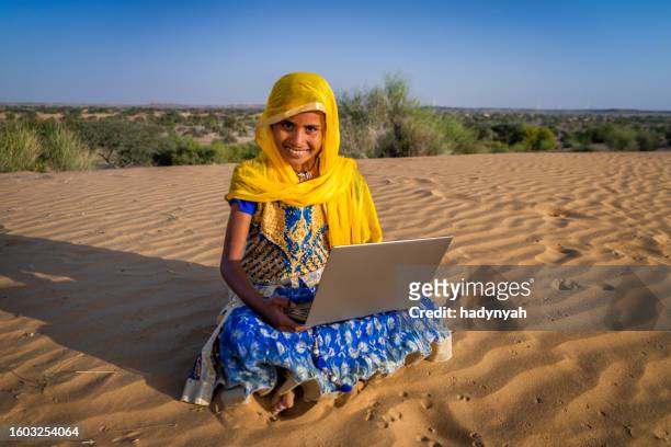 happy indian girl using a digital tablet, desert village, india - laptop desert stock pictures, royalty-free photos & images