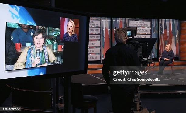 Secretary of State Hillary Clinton appears on a television screen as she talks with NDTV's Barkha Dutt during a "Global Townterview" at the Newseum...