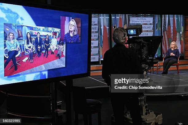 Secretary of State Hillary Clinton appears on a television screen as she answers questions from youths at the BBC's London offices during a "Global...
