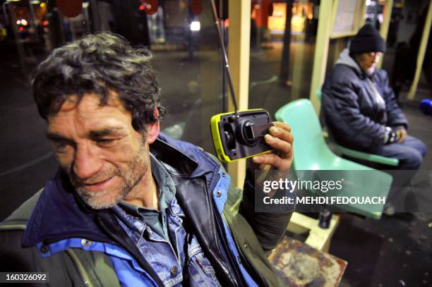 Embargoed until December 21, 2012 - 22:00 GMT / A homeless man listens to a radio distribued by members of the Association "Les Enfants du Canal", in...