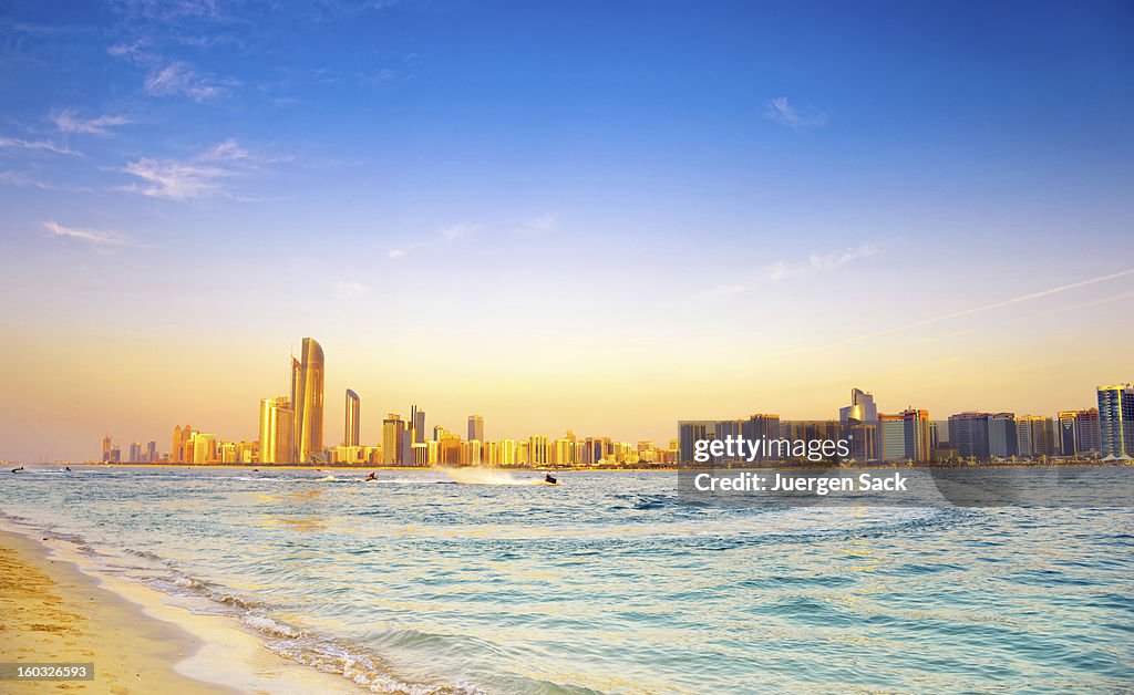 Com cenário de praia em Abu Dhabi da cidade ao pôr-do-sol