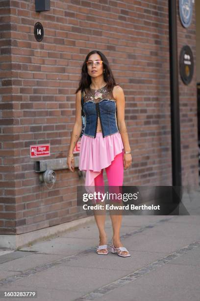 Guest wears glasses, silver earrings, a black tulle with embroidered yellow / pink / green flower pattern chest / navy blue denim shoulder-off corset...