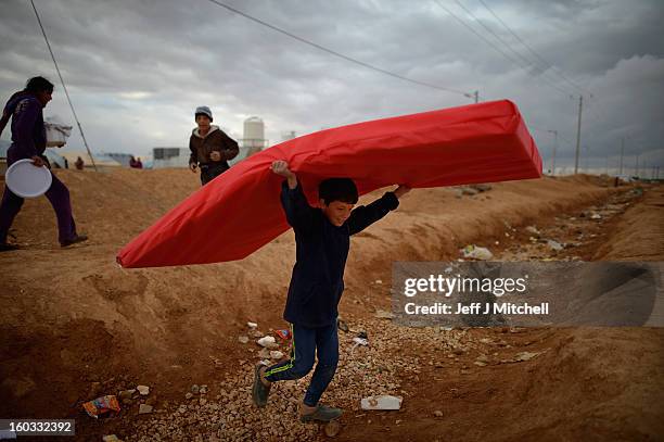 Boy carries a mattress as Syrian refugees go about their daily business in the Za’atari refugee camp on January 29, 2013 in Mafrq, Jordan. Record...