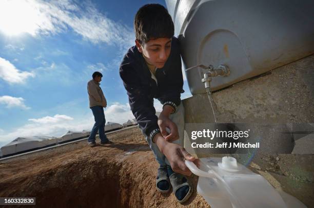 Syrian refugees gather water as they go about their daily business in the Za’atari refugee camp on January 29, 2013 in Mafraq, Jordan. Record numbers...