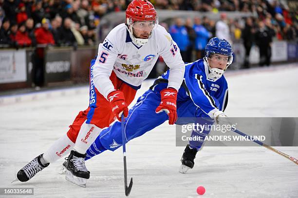 Russia's Alan Dzhusoev and Finland's Samuli Helavuori vie during the Bandy World Championship match between Finland and Russia in Trollhattan,...