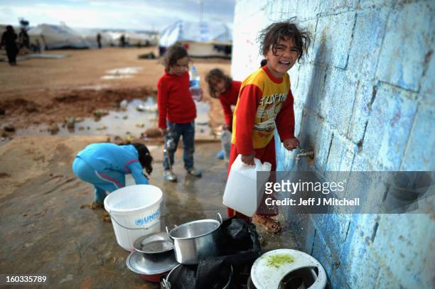 Children gather water as Syrian refugees go about their daily business in the Za’atari refugee camp on January 29, 2013 in Mafraq, Jordan. Record...