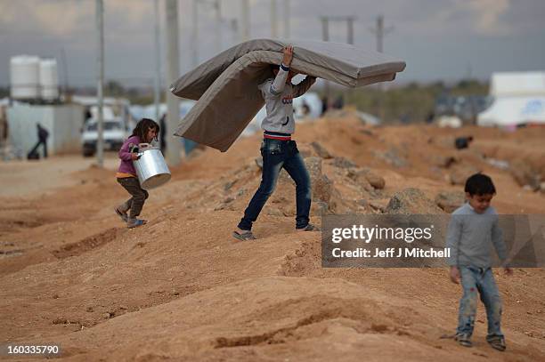 Boy carries a mattress as Syrian refugees go about their daily business in the Za’atari refugee camp on January 29, 2013 in Mafraq, Jordan. Record...