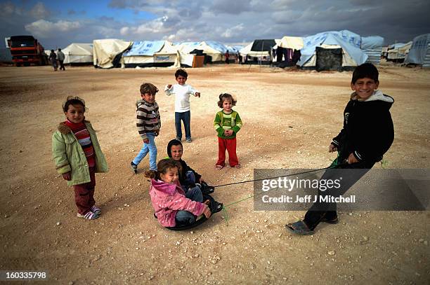 Children play as Syrian refugees go about their daily business in the Za’atari refugee camp on January 29, 2013 in Mafraq, Jordan. Record numbers of...