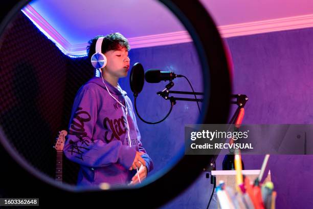 young boy singing with microphone and recording music in home studio. - escritor de canções imagens e fotografias de stock