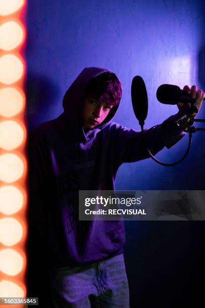 portrait photo of teenage singer photographed on blue background in home studio with neon light. - all hip hop models stock pictures, royalty-free photos & images